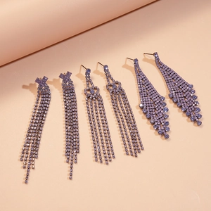 Three pairs of elegant purple rhinestone fringe tassel earrings on pink backdrop
