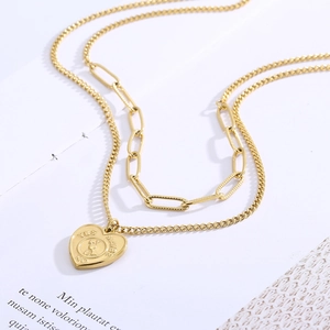 Detail of a gold layered necklace featuring a spinning heart pendant with Yes No Maybe