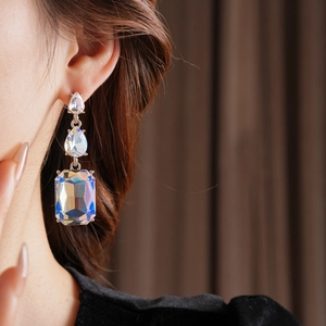 Detail of luxury teardrop and rectangle tassel earrings with iridescent crystal finish
