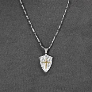 Vintage shield necklace for men featuring a gold cross on a textured silver pendant