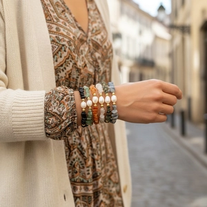 Close-up of stacked elastic bracelets with colorful gravel stones and baroque pearls