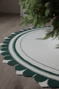 Dettaglio del tappeto per albero di Natale in maglia crema con motivi a onde verdi