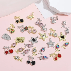 Detailed flat lay of Y2K DIY jewelry pendants with colorful rhinestones on pink background