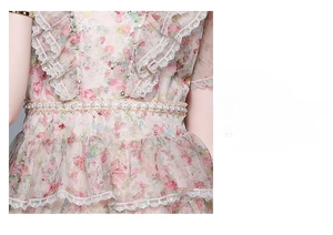 Détail d'une robe en tulle fleuri avec broderie de perles et volants en dentelle