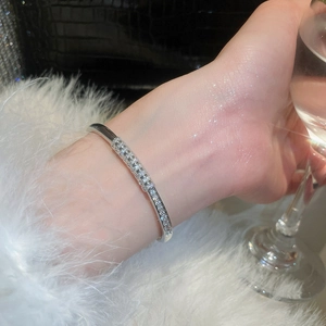 Macro detail of silver-plated bangle with pavé-set zircons on a model wrist