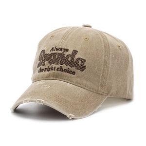 Close-up of khaki washed cotton baseball cap with vintage distressed holes and embroidery