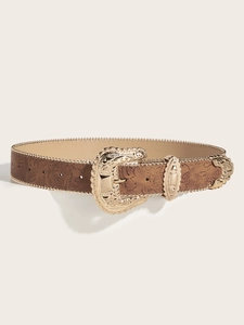 Detail of brown embossed leather belt featuring an ornate gold Western-style buckle