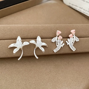 Detailaufnahme floraler Silberstecker mit Lilien- und Rosendesign auf Schmuckständer