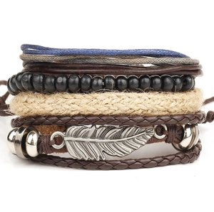 Multilayer bohemian braided bracelet set featuring leather cords, beads and silver feather charm