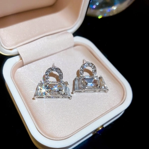 Macro view of silver handbag stud earrings with square crystals in a pink jewelry box