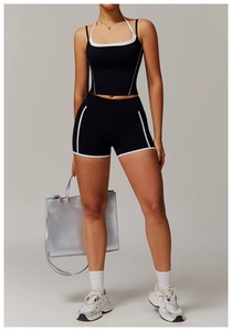 Détail d'un ensemble de yoga deux pièces avec haut dos nu noir et short à liseré contrasté