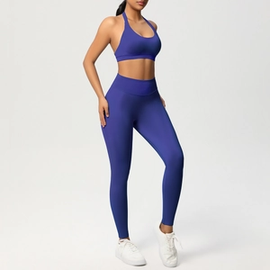 Vista laterale del set yoga a coste blu scuro con reggiseno allacciato al collo e leggings a vita alta