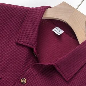 Primer plano de cuello de camisa burdeos de tejido gofrado con etiqueta de talla M