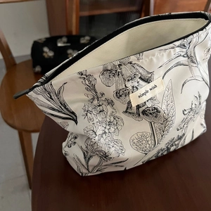 Detailed macro shot of vintage floral pattern on canvas cosmetic bag with zipper