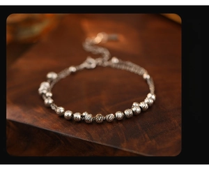 Macro detail of S925 silver double-layer bracelet with carved beads and adjustable clasp