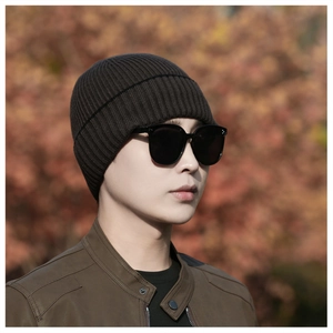 Outdoor shot of a man wearing a dark brown ribbed knit beanie for winter warmth