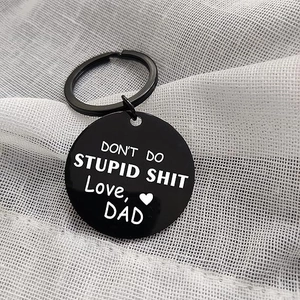 Close-up of black stainless steel keychain with white engraved text Love Dad