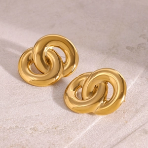 Polished 18k gold plated double interlocking hoop earrings on a beige stone surface