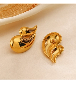 Detailed view of polished 18K gold plated heart earrings on beige silk fabric