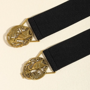 Detail of black elastic waist belts with bronze crane and reed buckle for dresses