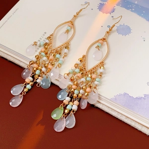 Detail of bohemian teardrop earrings with colorful bead tassels and crystal pendants