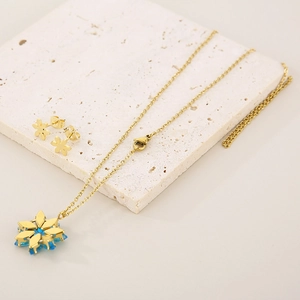 Elegant gold flower jewelry set featuring blue gemstone pendant necklace and matching studs