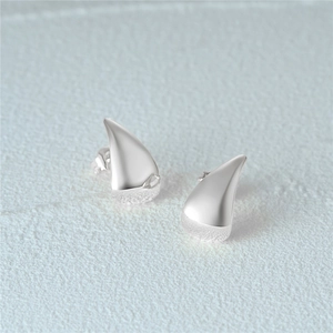 Macro shot of silver C-shaped horn stud earrings with polished and frosted metal texture