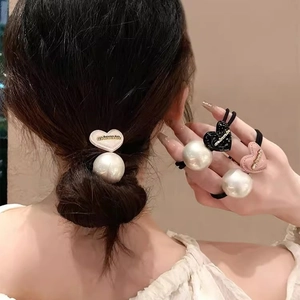 Trois chouchous élégants avec cœurs et perles en noir, rose et crème pour coiffures chic