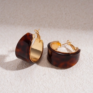 Detail view of retro resin tortoise shell C-shape hoop earrings with gold inner lining