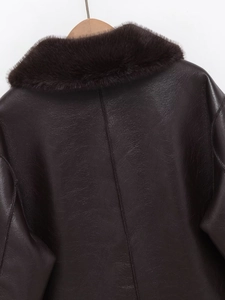 Detail view of the back of a dark brown leather jacket with a plush faux fur collar