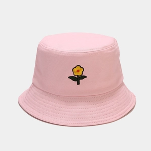 Dettaglio di un cappello a secchiello in tela rosa con ricamo di margherita gialla