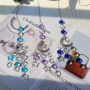 Bohemian crystal suncatcher with moon and star prisms reflecting natural rainbow light