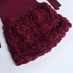 Détail des appliques de roses 3D sur une robe de soirée évasée rouge vin à épaules dénudées