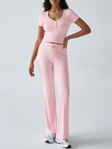 Vista completa del set loungewear in maglia a coste rosa con top a V e pantaloni flare