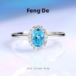 Macro shot of S925 silver ring featuring an oval blue stone with a halo of white zircons