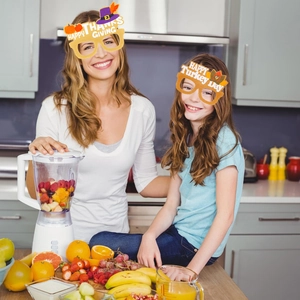 Close-up of Thanksgiving glasses with turkey and pumpkin motifs worn by a mother and child