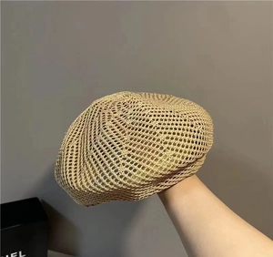 Detailed view of hollow breathable straw knit beret hat in natural light beige texture