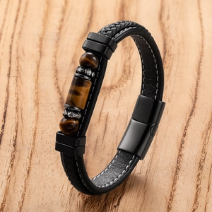 Detailed macro view of men's leather bracelet featuring tiger eye beads and metal magnetic clasp