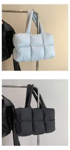 Close-up of quilted down puffer tote bags in light blue and black soft checkered texture