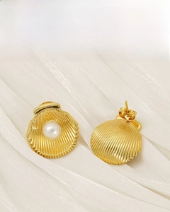 Detailed view of 18K gold plated shell earrings with white pearls on silk background