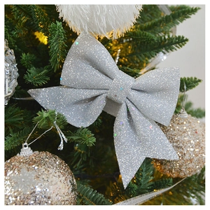 Close-up of a silver sequined bow ornament hanging on a festive Christmas tree branch