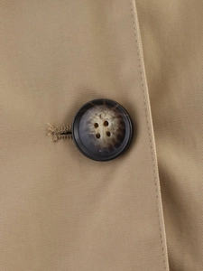 Detailed macro view of khaki twill cotton fabric texture and tortoise shell button