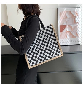Close-up of a checkered linen tote bag worn by a model in a natural lifestyle setting