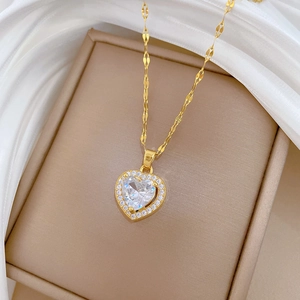 Elegant gold titanium necklace featuring a heart-shaped zircon pendant on silk background