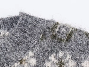 Close-up of thick jacquard knit fabric with brushed grey mohair texture and retro pattern