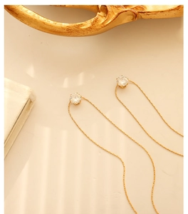 Detail view of elegant 18K gold plated long chain threader earrings with round cubic zirconia