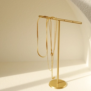 Detailansicht der 18K vergoldeten Schlangenkette und O-Kette auf einem Metallständer