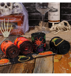 Detail of Halloween ribbons with spider and pumpkin patterns on a rustic wooden table