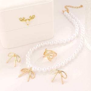 Elegant vintage jewelry set with pearl necklace, bow earrings and ring in a white gift box