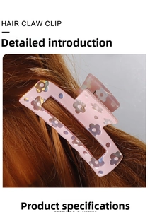 Detailed view of pink floral hair claw clip with cutout design worn on long brown hair